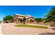 A charming home features a well-manicured front yard with a stone fountain and mature trees at 5216 W Oraibi Dr, Glendale, AZ 85308