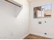 Bright laundry room with window and wood-look floors and light walls at 5216 W Oraibi Dr, Glendale, AZ 85308
