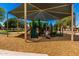 Community playground featuring covered play structures and slides, surrounded by wood chip ground cover at 5216 W Oraibi Dr, Glendale, AZ 85308