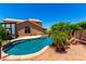 Inviting backyard pool area surrounded by lush landscaping and a house at 5216 W Oraibi Dr, Glendale, AZ 85308