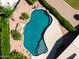 Inviting backyard pool featuring a rock waterfall, lush landscaping, and a basketball hoop for added fun at 5216 W Oraibi Dr, Glendale, AZ 85308