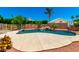 Backyard pool with lush trees and landscaping and a basketball hoop at 5216 W Oraibi Dr, Glendale, AZ 85308