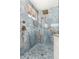Close up of the beautifully tiled marble shower with brass fixtures and custom shower head at 5216 W Oraibi Dr, Glendale, AZ 85308