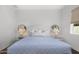 Bright bedroom featuring a padded headboard, matching bedside tables with lamps, and round mirrors at 5542 E Alan Ln, Paradise Valley, AZ 85253