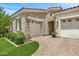Stone exterior elevation with two car garage, arched entry, and manicured landscaping at 5542 E Alan Ln, Paradise Valley, AZ 85253