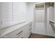Walk-in closet features custom shelving, drawers and wood shutters on window at 6019 E Windsor Ave, Scottsdale, AZ 85257