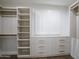 Walk-in closet with custom shelves, drawers and window with wood shutters at 6019 E Windsor Ave, Scottsdale, AZ 85257