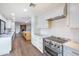 Modern kitchen featuring white cabinets, quartz countertops, stainless steel appliances, and hardwood floors at 6019 E Windsor Ave, Scottsdale, AZ 85257