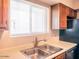 Well-lit kitchen sink with window view, cabinets, and appliances at 7474 E Earll Dr # 311, Scottsdale, AZ 85251