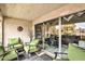 Relax on this shaded balcony with green armchairs, small tables, and sliding glass doors to the living area at 7625 E Camelback Rd # A249, Scottsdale, AZ 85251