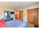 Cozy bedroom featuring wood closets and a large dresser with decor and mounted TV at 7625 E Camelback Rd # A249, Scottsdale, AZ 85251