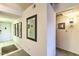 Clean hallway with tiled flooring, mirrors, and artwork, leading to the interior of the home at 7625 E Camelback Rd # A249, Scottsdale, AZ 85251
