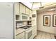 Bright kitchen showcases a microwave, range, and complementary cabinetry, adjacent to the hallway at 7625 E Camelback Rd # A249, Scottsdale, AZ 85251