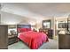 Spacious main bedroom with a red quilt, featuring elegant furniture and a view into the bathroom at 7625 E Camelback Rd # A249, Scottsdale, AZ 85251