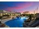 Stunning backyard featuring a custom pool with rock accents and lush desert landscaping at dusk at 9022 E Diamond Rim Dr, Scottsdale, AZ 85255