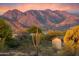 Exterior view of home surrounded by desert landscape with mountainous view in the background at 9022 E Diamond Rim Dr, Scottsdale, AZ 85255