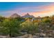 Exterior daytime view of home surrounded by lush landscaping with views of mountains at 9022 E Diamond Rim Dr, Scottsdale, AZ 85255