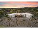 Stunning desert home featuring a circular driveway, two garages, and desert landscaping under a beautiful sunset sky at 9022 E Diamond Rim Dr, Scottsdale, AZ 85255