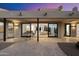 Covered patio with travertine pavers and dining table and view to the home's great room beyond at 9022 E Diamond Rim Dr, Scottsdale, AZ 85255