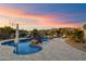 Custom pool with rock waterfall feature surrounded by desert plants and lounge chairs, perfect for relaxation at 9022 E Diamond Rim Dr, Scottsdale, AZ 85255