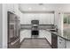 Modern kitchen featuring stainless steel appliances, granite countertops, and sleek white cabinetry at 10352 E Sebring Ave, Mesa, AZ 85212