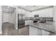 Well-lit kitchen boasts stainless appliances, granite countertops, and stylish white cabinetry at 10352 E Sebring Ave, Mesa, AZ 85212