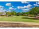 A community park with a vast green lawn surrounded by trees, offering a serene and open space at 10352 E Sebring Ave, Mesa, AZ 85212