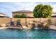 Serene backyard pool featuring a rock waterfall, lounge chairs, and privacy fencing, creating a peaceful retreat at 10617 W Daley Ln, Peoria, AZ 85383