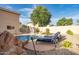 Backyard pool featuring a slide, lounge chairs, and lush landscaping creating a private and relaxing oasis at 10617 W Daley Ln, Peoria, AZ 85383