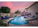 Inviting backyard pool area featuring a rock waterfall, slide, and comfortable lounge seating, ideal for entertaining at 10617 W Daley Ln, Peoria, AZ 85383