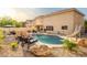 Expansive backyard with a sparkling pool, rock waterfall, slide, and multiple seating areas for ultimate outdoor enjoyment at 10617 W Daley Ln, Peoria, AZ 85383