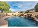 Sparkling backyard pool with a rock waterfall, slide, and comfortable lounge chairs for ultimate relaxation and enjoyment at 10617 W Daley Ln, Peoria, AZ 85383