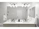 Bright bathroom vanity featuring dual sinks, modern lighting fixtures, and neutral paint at 10617 W Daley Ln, Peoria, AZ 85383