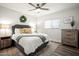 Cozy bedroom features a comfortable bed, wood-look flooring and lots of natural light at 10617 W Daley Ln, Peoria, AZ 85383