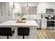 Kitchen with island seating, stainless steel appliances, modern lighting and stylish backsplash at 10617 W Daley Ln, Peoria, AZ 85383