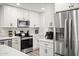 Bright kitchen featuring stainless steel appliances, white cabinets, and stylish backsplash at 10617 W Daley Ln, Peoria, AZ 85383