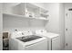 Well-equipped laundry room featuring modern appliances and open shelving for storage at 10617 W Daley Ln, Peoria, AZ 85383