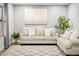 Cozy living area featuring a comfortable sofa with pillows, a decorative rug, and a charming potted plant at 10617 W Daley Ln, Peoria, AZ 85383