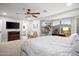 Bright main bedroom featuring a ceiling fan, office area, and ensuite bathroom for convenience at 10617 W Daley Ln, Peoria, AZ 85383