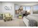 Bright bedroom with desk area, a floral armchair, and plenty of natural light at 10617 W Daley Ln, Peoria, AZ 85383