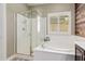 Lovely bathroom with soaking tub, glass shower, tile flooring, and wood accent wall at 10738 W Rowel Rd, Peoria, AZ 85383