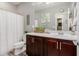 Bathroom boasts dark wood vanity, framed mirror, and shower with white shower curtain at 10738 W Rowel Rd, Peoria, AZ 85383