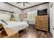 Bedroom featuring a large mirror, ceiling fan, wood floors, and wooden dresser with TV at 10738 W Rowel Rd, Peoria, AZ 85383