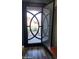 View of the custom iron front door and screen door with detailed circular design and wood-look tile flooring at 10738 W Rowel Rd, Peoria, AZ 85383