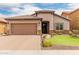 Inviting single-story home boasting a tiled roof, neutral stucco, stone accents and manicured lawn at 10738 W Rowel Rd, Peoria, AZ 85383