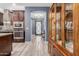 Bright hallway with wood-look tile, an eye-catching wooden cabinet, and a view of the patterned glass front door at 10738 W Rowel Rd, Peoria, AZ 85383