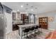 Open kitchen features granite island with barstool seating, stainless appliances, and dark cabinetry at 10738 W Rowel Rd, Peoria, AZ 85383