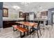 Open kitchen features dark wood cabinets, stainless steel appliances, large island and a dining table at 10738 W Rowel Rd, Peoria, AZ 85383