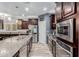 Beautiful kitchen with stainless steel appliances, dark wood cabinets, and granite countertops at 10738 W Rowel Rd, Peoria, AZ 85383