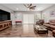 Spacious living room with hardwood floors, a ceiling fan, and a comfortable leather sofa at 10738 W Rowel Rd, Peoria, AZ 85383
